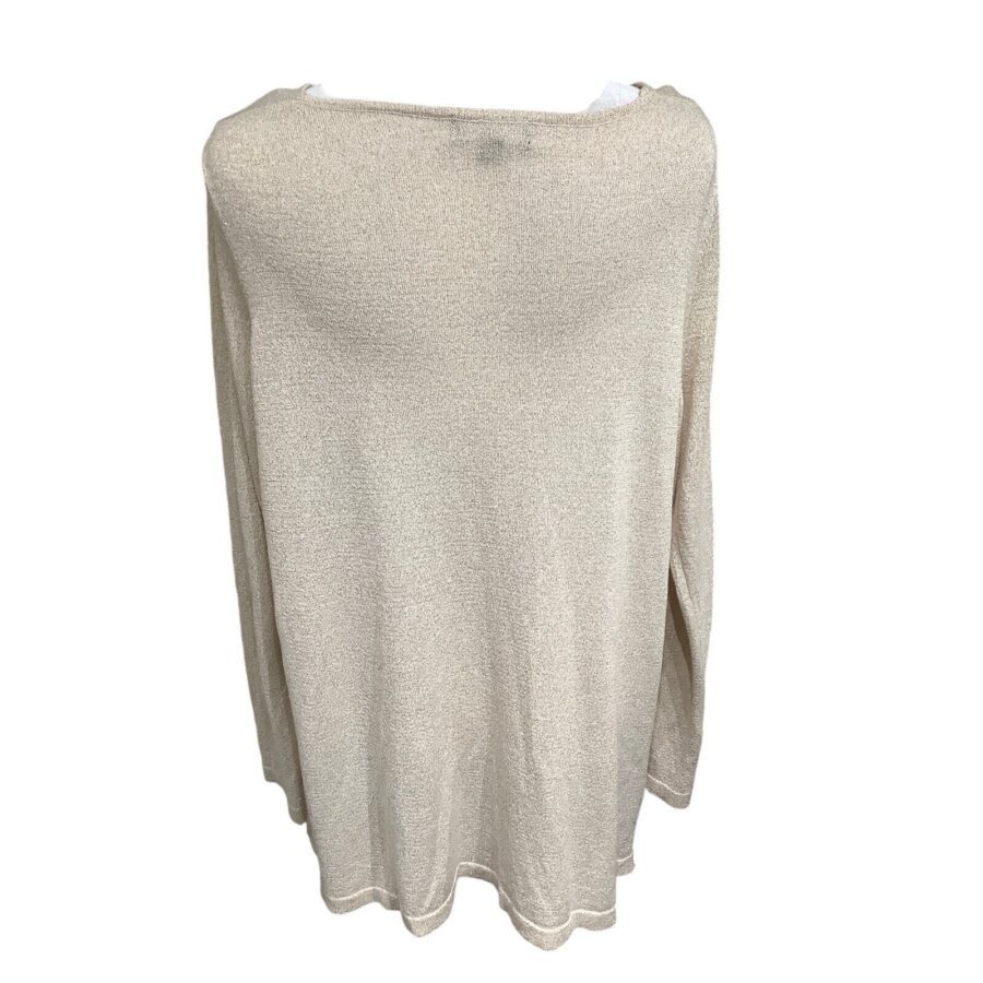 A light beige knit sweater is displayed on a hanger, showcasing its simple, loose fit and minimal design without any visible landmarks or historical buildings.