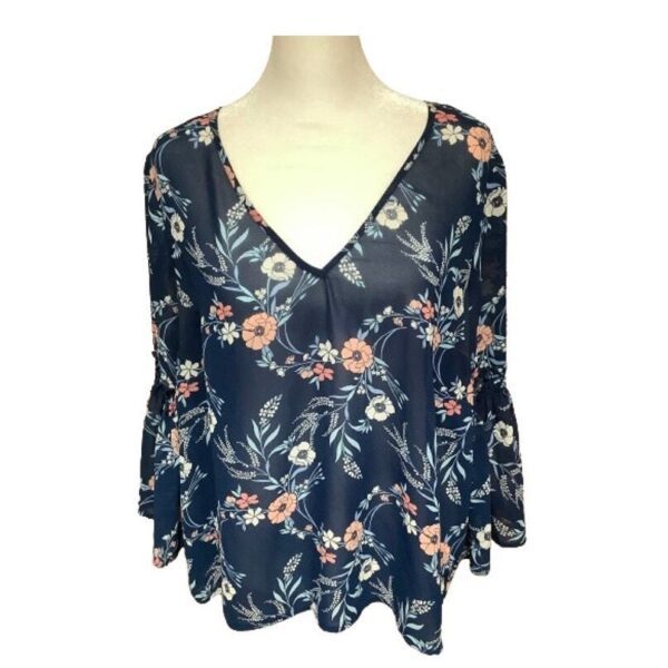 The image shows a dark blue, floral-patterned blouse with a V-neck and flared sleeves, displayed on a white mannequin torso.