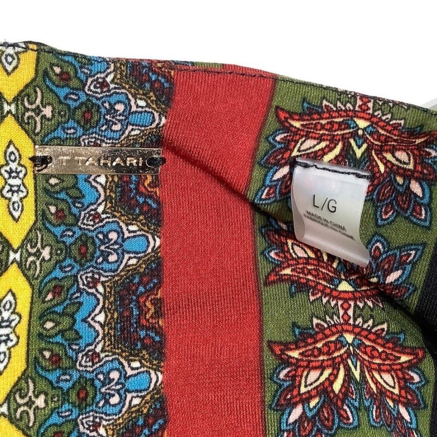 A piece of colorful patterned fabric with a "T Tahari" metal label and an "L/G" size tag, showcasing intricate designs and vibrant colors.