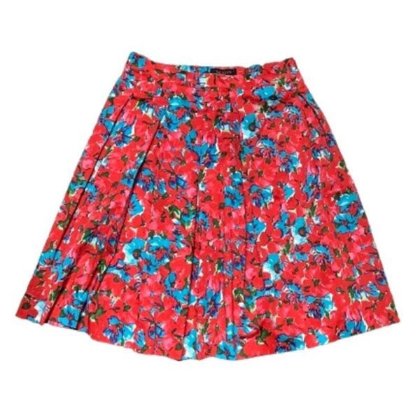 A vibrant floral skirt featuring red, blue, and green hues with pleated design. The skirt has a high-waisted fit and a knee-length hemline.