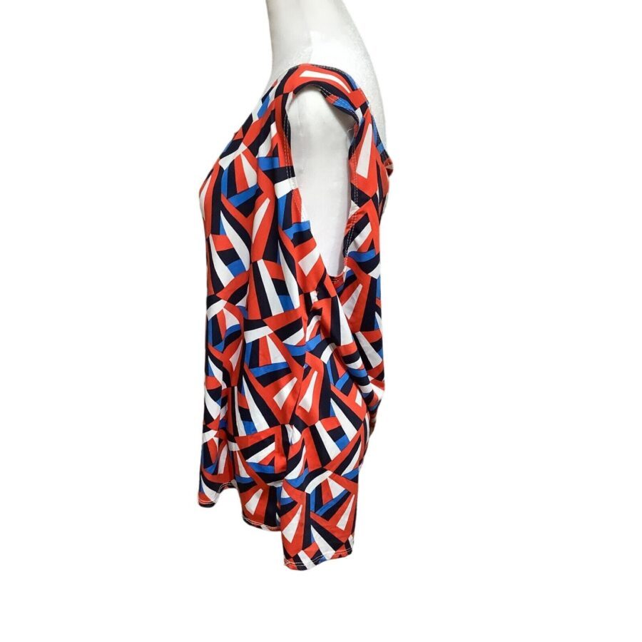 A mannequin dressed in a colorful, geometric-patterned sleeveless top. The pattern includes red, blue, white, and black colors arranged in abstract shapes.