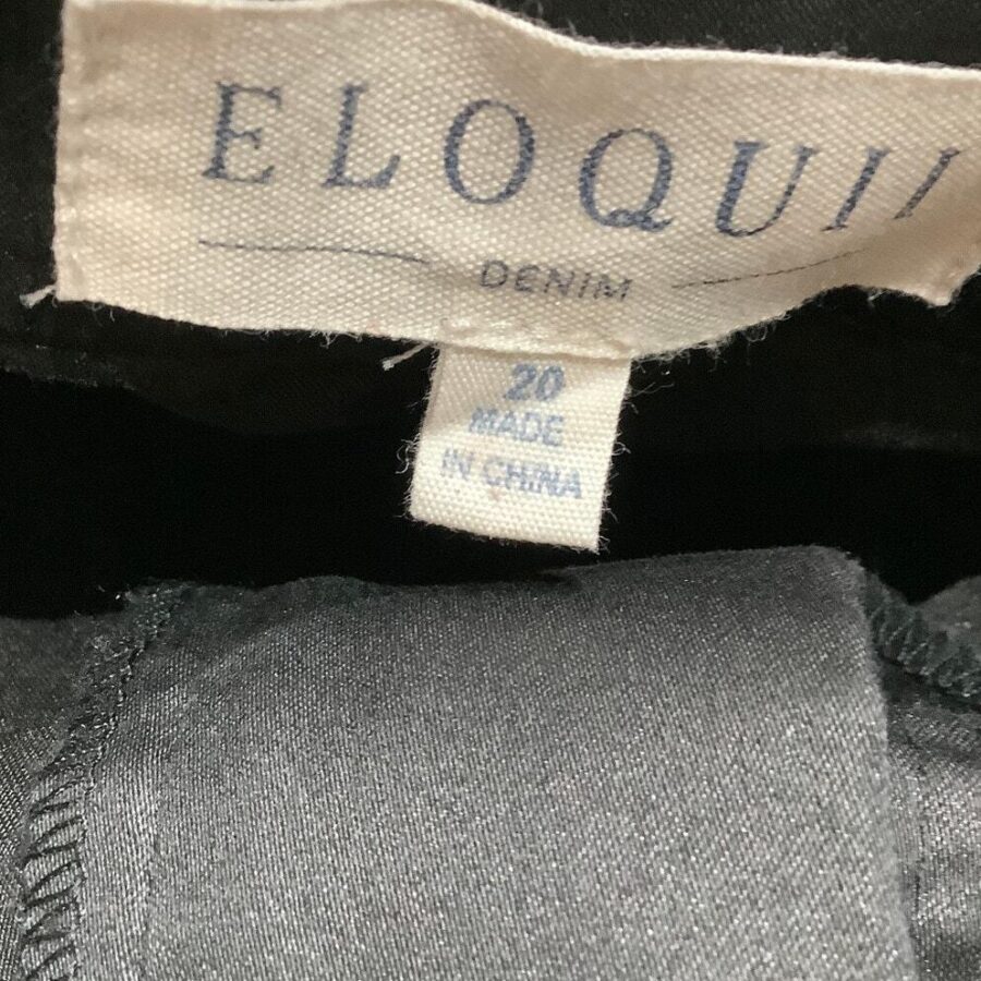 The image shows a clothing label from Eloquii Denim, indicating size 20 and made in China. The fabric appears to be dark-colored denim.