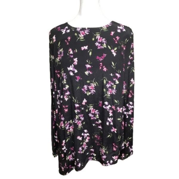 A floral-patterned black blouse is displayed on a white mannequin. The blouse features purple, pink, and green flower designs. No background is visible.