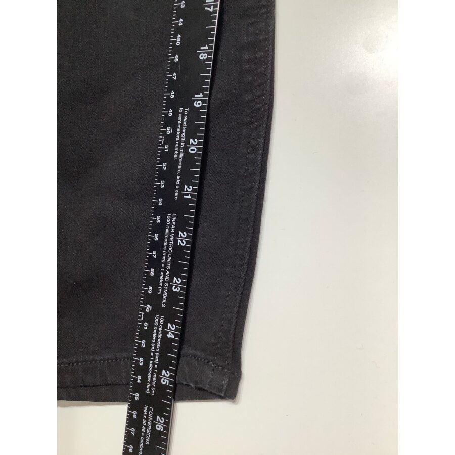 A close-up image of a black fabric next to a black ruler on a white surface. The ruler shows measurements in inches and centimeters.