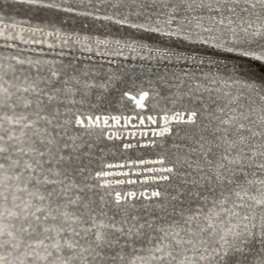 Close-up of a dark gray American Eagle Outfitters shirt label, indicating it is made in Vietnam and available in size S/P/CH.